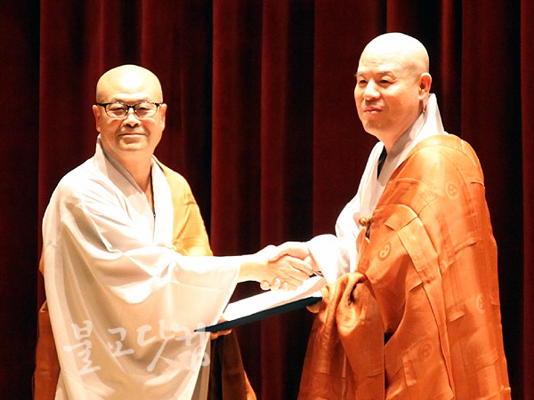 ▲ 압도적 지지로 당선된 자승 스님(오른쪽)이 중앙선거관리위원장 심경 스님으로부터 당선증을 전달 받고 있다.