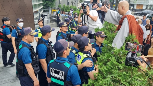 주한일본대사관 앞 화단에 올라 일본 정부의 악행 중단을 촉구하는 조계종 사회노동위원 법우 스님.